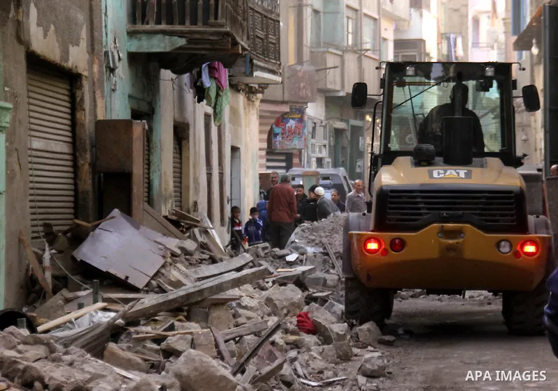 Egyptians and rescue workers inspect the site of a collapsed two-storey building in the Cairo district of Torgoman, December 9, 2014. The Ministry of Health and Population of Egypt injuring two people in the collapse of...