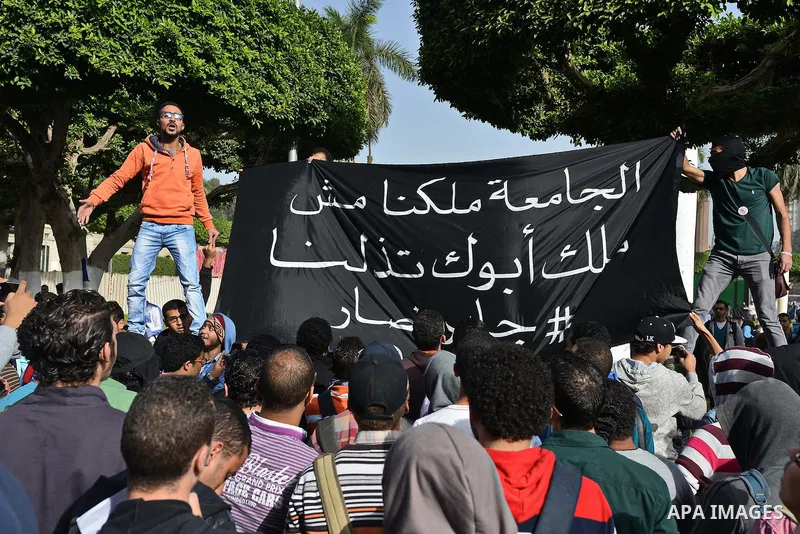 Egyptian students, who are members of Students Against the Coup group (SAC), take part in a demonstration against the military rule, at Cairo University on December 9, 2014. Photo by Amr Sayed
