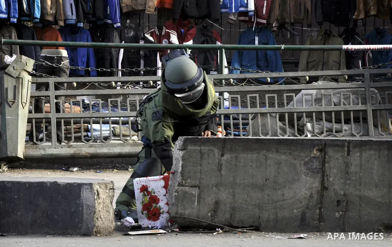 An Egyptian explosive expert tries to dismantle a home-made bomb close to downtown Ramses Square, Cairo December 9, 2014. Egypt has seen a wave of bombings and shootings, mainly against army and police personnel, over th...
