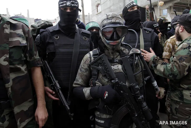 Palestinian militants from the Ezzedine al-Qassam brigade take part during a rally to commemorate the 27th anniversary of the Islamist movement s creation, at the Nuseirat refugee camp in the Central Gaza Strip on Decemb...