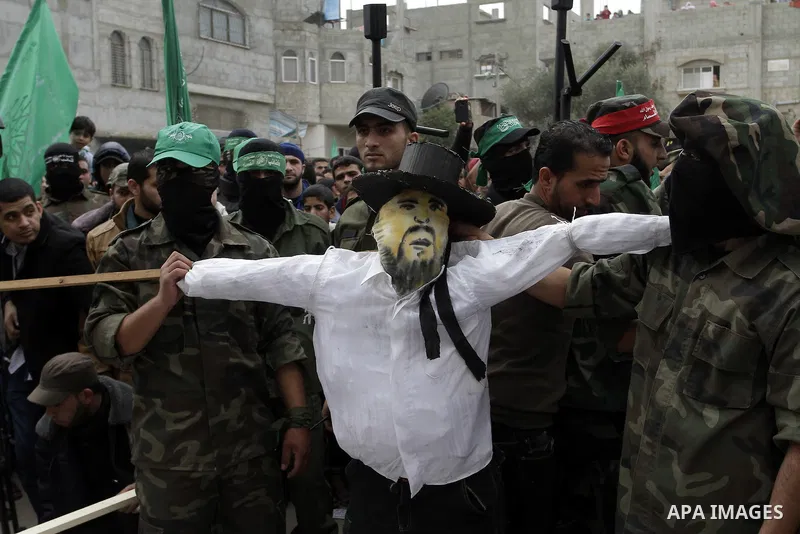 Palestinian militants from the Ezzedine al-Qassam brigade take part during a rally to commemorate the 27th anniversary of the Islamist movement s creation, at the Nuseirat refugee camp in the Central Gaza Strip on Decemb...