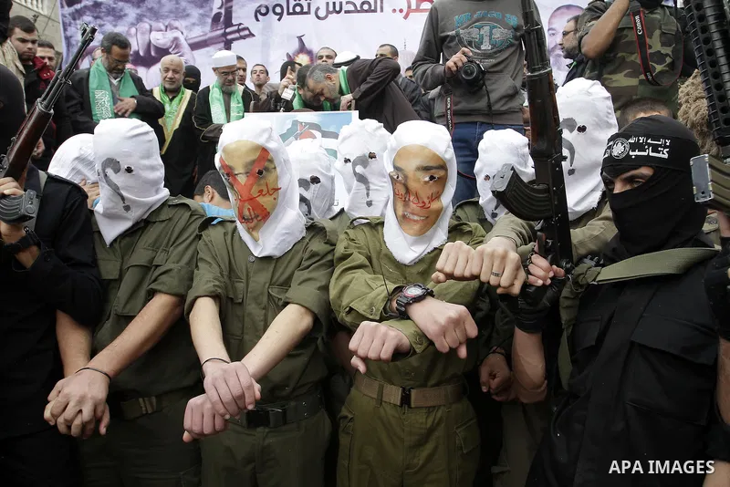 Palestinian militants from the Ezzedine al-Qassam brigade take part during a rally to commemorate the 27th anniversary of the Islamist movement s creation, at the Nuseirat refugee camp in the Central Gaza Strip on Decemb...