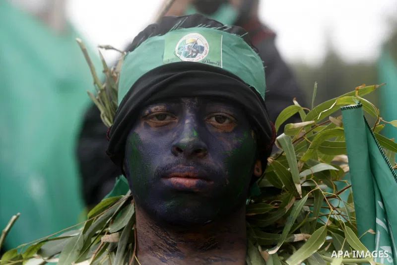 Palestinian militants from the Ezzedine al-Qassam brigade take part during a rally to commemorate the 27th anniversary of the Islamist movement s creation, at the Nuseirat refugee camp in the Central Gaza Strip on Decemb...