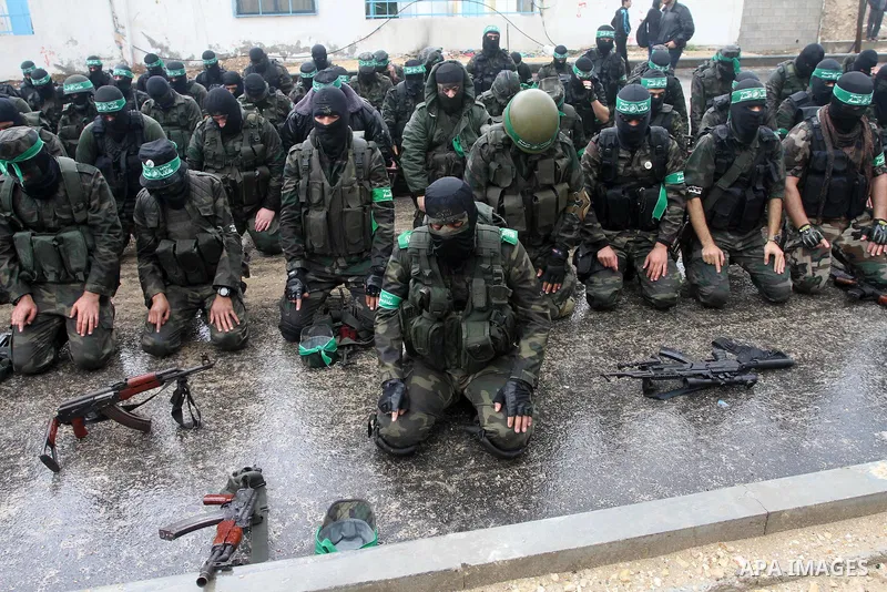 Palestinian members of al-Qassam Brigades, the armed wing of the Hamas movement, pray during a military parade marking the 27th anniversary of Hamas' founding, in Gaza City December 14, 2014. Photo by Mohammed Asad