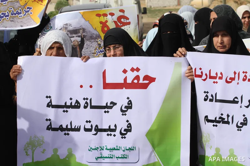 Palestinians gather during a protest against the delay in acquiring building material in front of Eriz crossing border, in the norhtern Gaza Strip on December 18, 2014. According to housing minister Mufeed al-Hasayna, Ga...