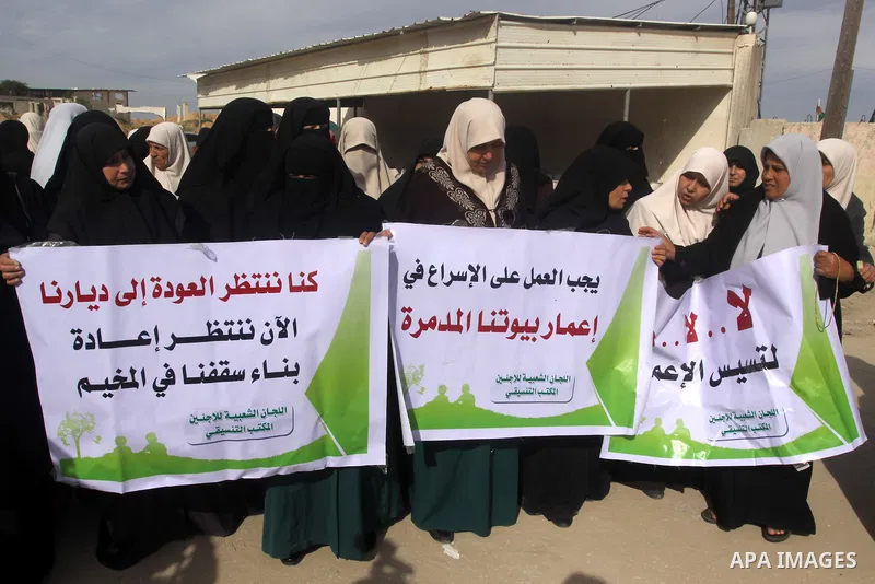 Palestinians gather during a protest against the delay in acquiring building material in front of Eriz crossing border, in the norhtern Gaza Strip on December 18, 2014. According to housing minister Mufeed al-Hasayna, Ga...