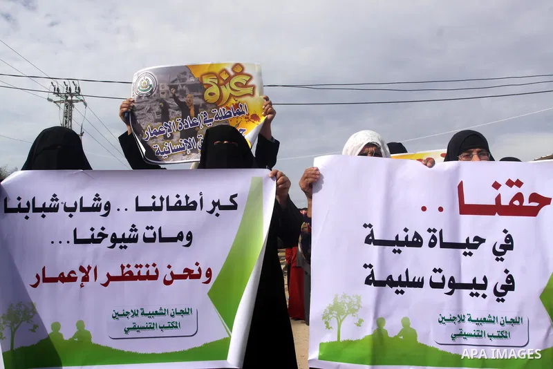Palestinians gather during a protest against the delay in acquiring building material in front of Eriz crossing border, in the norhtern Gaza Strip on December 18, 2014. According to housing minister Mufeed al-Hasayna, Ga...