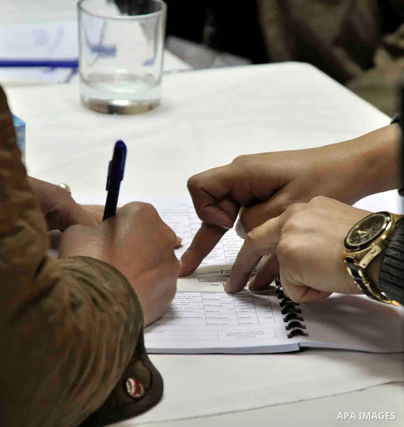 A Tunisian woman living in Egypt casts her ballot in Cairo, Egypt, Dec. 19, 2014. Overseas Tunisians started voting on Friday as Tunisia's second round of presidential election will be held in Tunisia on Dec. 21, 2014. P...