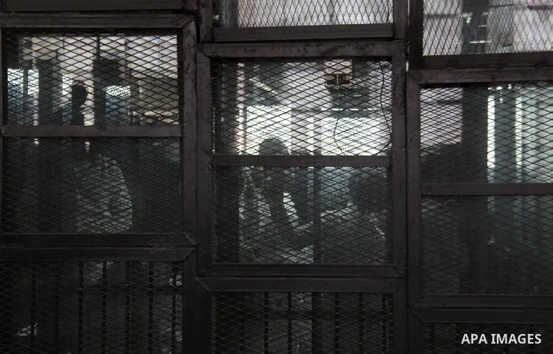 Political activist Alaa Abdel Fattah with 24 others, stand inside the defendants cage during their trial, in Cairo, Egypt, on December 20, 2014. The court postponed to December 27 the verdict in the trial of the Events E...