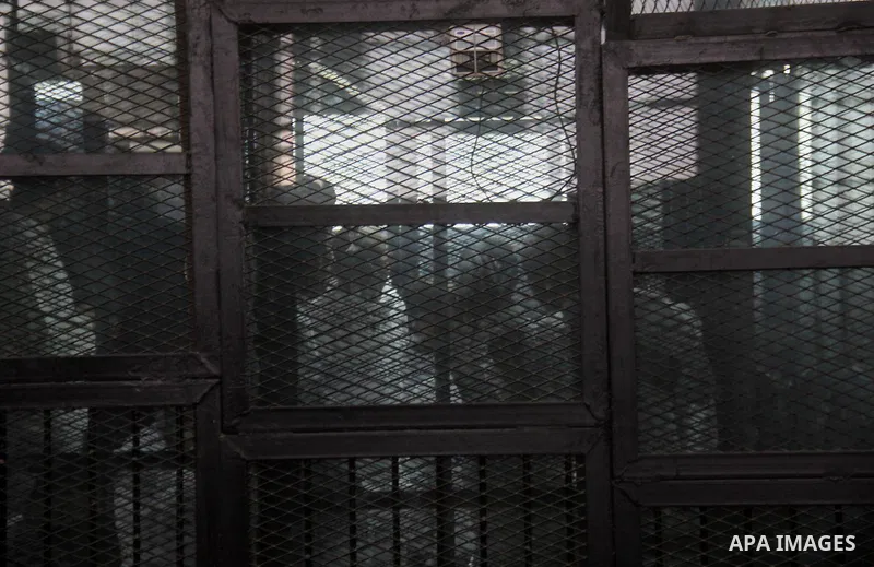 Political activist Alaa Abdel Fattah with 24 others, stand inside the defendants cage during their trial, in Cairo, Egypt, on December 20, 2014. The court postponed to December 27 the verdict in the trial of the Events E...