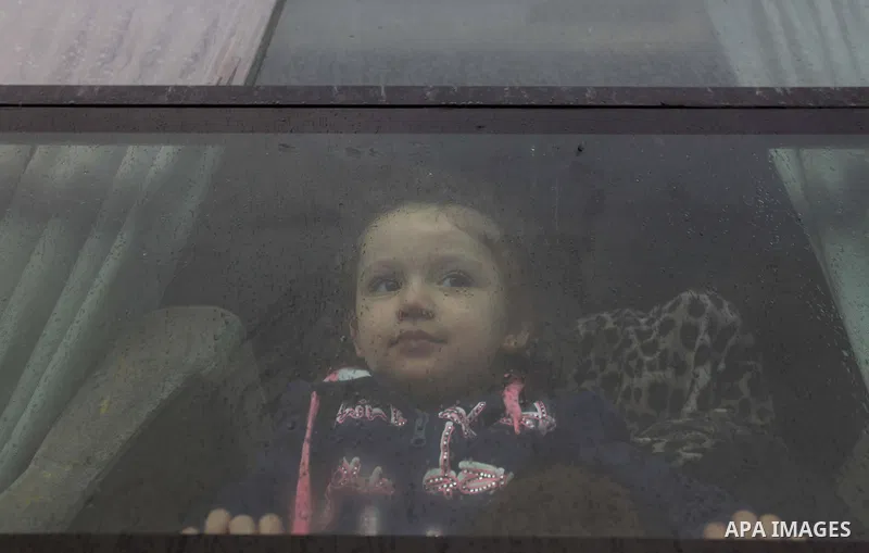 A Palestinian girl, hoping to cross into Egypt with her family, looks out a bus window at the Rafah crossing between Egypt and the southern Gaza Strip December 21, 2014. Egypt opened the Rafah border crossing on Sunday a...