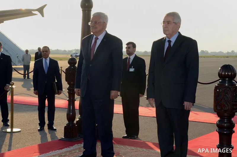 Palestinian president Mahmoud Abbas is welcomed by Algerian President of the Council of the Nation Abdelkader Bensalah upon his arrival at Houari Boumediene Airport outside the capital Algiers on December 21, 2014. Abbas...