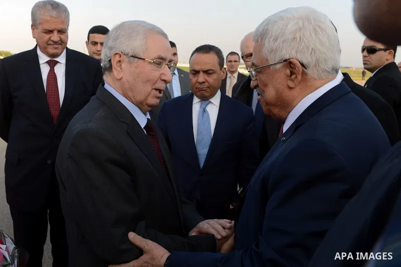 Palestinian president Mahmoud Abbas is welcomed by Algerian President of the Council of the Nation Abdelkader Bensalah upon his arrival at Houari Boumediene Airport outside the capital Algiers on December 21, 2014. Abbas...