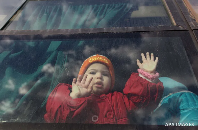 A Palestinian girl, hoping to cross into Egypt with her family, looks out a bus window at the Rafah crossing between Egypt and the southern Gaza Strip December 23, 2014. Egypt opened the Rafah border crossing on Sunday f...
