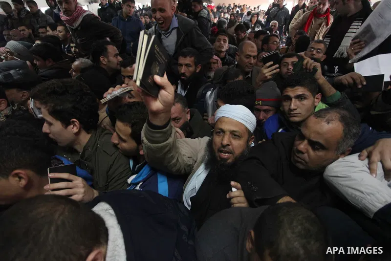 Palestinians present their passports as they ask for permits to cross into Egypt at the Rafah border crossing between Egypt and the southern Gaza Strip December 23, 2014. Egypt opened the Rafah border crossing on Sunday...