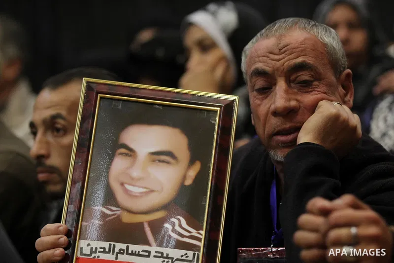 A relative of a killed man in the 'Port Said Massacre' holds his picture during the trial of suspects in Cairo on December 23, 2014. The defendants were originally given sentences ranging from 15 years to life in prison....