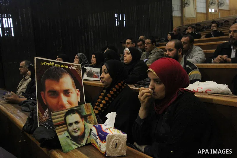 A relative of a killed man in the 'Port Said Massacre' holds his picture during the trial of suspects in Cairo on December 23, 2014. The defendants were originally given sentences ranging from 15 years to life in prison....