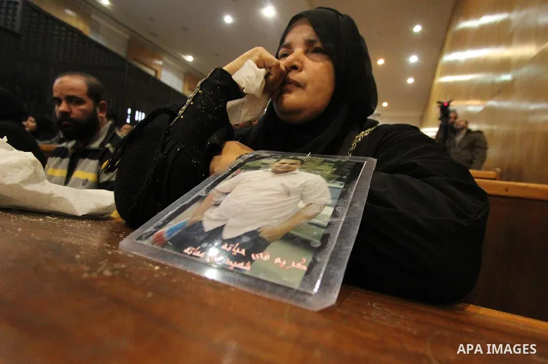 A relative of a killed man in the 'Port Said Massacre' holds his picture during the trial of suspects in Cairo on December 23, 2014. The defendants were originally given sentences ranging from 15 years to life in prison....