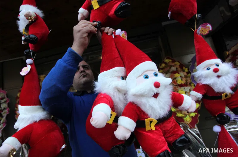 A Palestinian vendor decorates his shop with santa claus toys, celebrating the Christmas holiday in Gaza city on December 24, 2014. Photo by Ashraf Amra