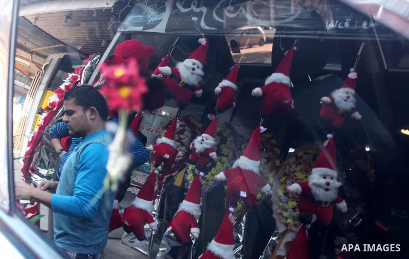 A Palestinian vendor decorates his shop with santa claus toys, celebrating the Christmas holiday in Gaza city on December 24, 2014. Photo by Ashraf Amra