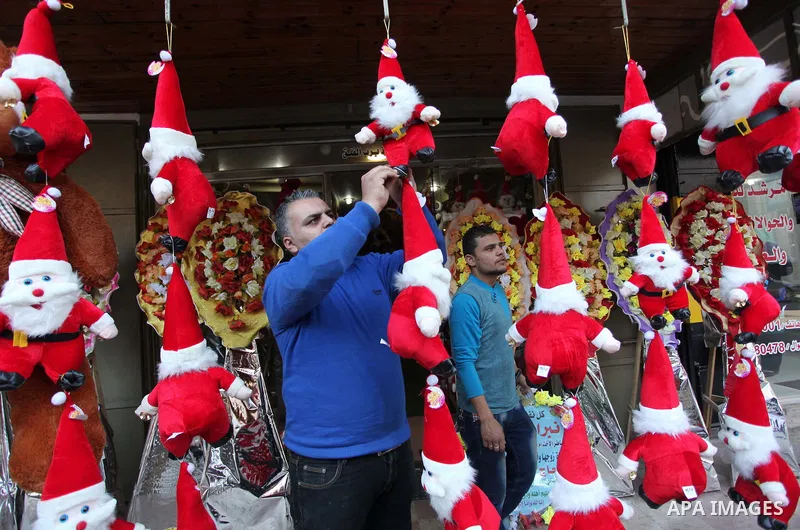 A Palestinian vendor decorates his shop with santa claus toys, celebrating the Christmas holiday in Gaza city on December 24, 2014. Photo by Ashraf Amra