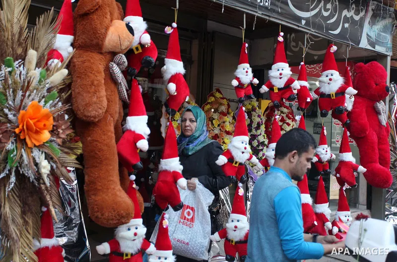 A Palestinian vendor decorates his shop with santa claus toys, celebrating the Christmas holiday in Gaza city on December 24, 2014. Photo by Ashraf Amra