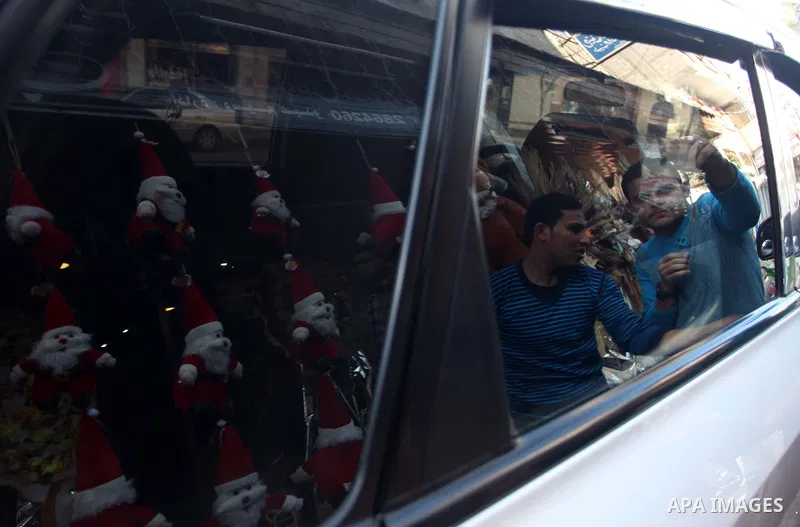 A Palestinian vendor decorates his shop with santa claus toys, celebrating the Christmas holiday in Gaza city on December 24, 2014. Photo by Ashraf Amra