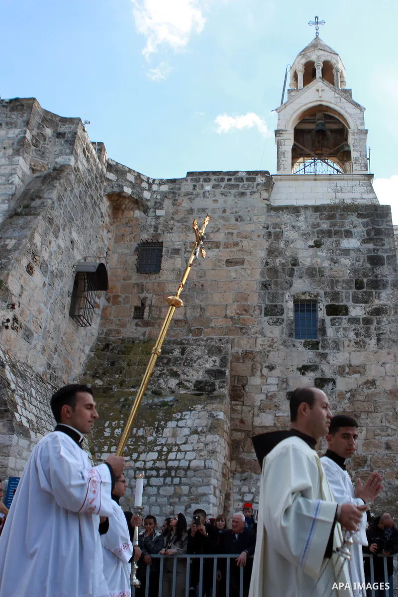 Members of the clergy attend the celebration outside the Church of the Nativity to attend Christmas in the West Bank town of Bethlehem December 24, 2014, as thousands of Christian pilgrims descended on Bethlehem to celeb...