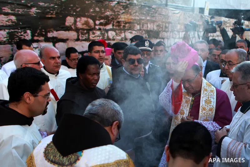 The Latin Patriarch of Jerusalem Fouad Twal prays upon his arrival to the Church of the Nativity to attend Christmas celebrations in the West Bank town of Bethlehem December 24, 2014, as thousands of Christian pilgrims d...