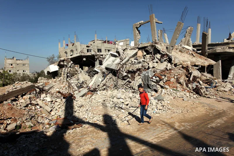 A Palestinian boy walks in front the rubble of houses which were destroyed during the recent Israeli offensive on Gaza Strip, in Shijaiyah neighborhood, east Gaza city December 25, 2014. Photo by Ashraf Amra