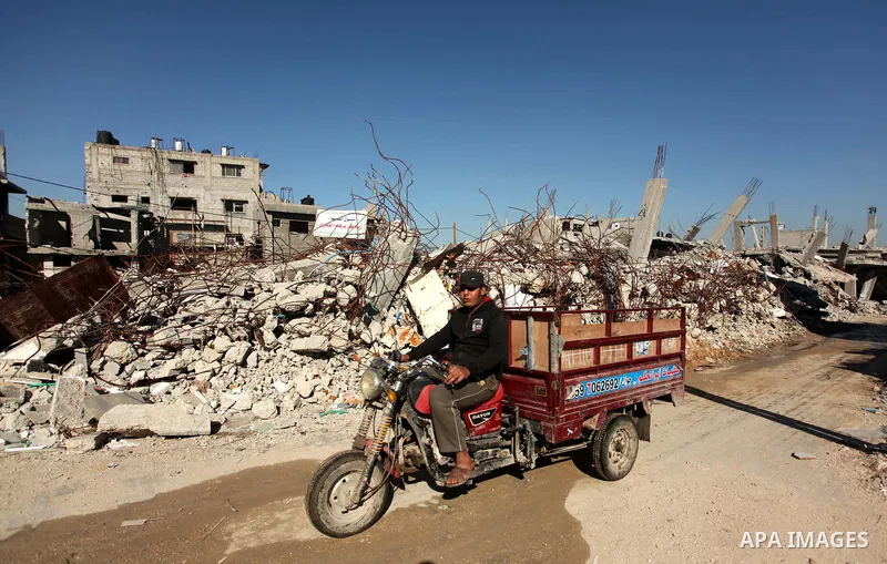 A Palestinian youth rides a motorcycle between the rubble of houses which were destroyed during the recent Israeli offensive on Gaza Strip, in Shijaiyah neighborhood, east Gaza city December 25, 2014. Photo by Ashraf Amr...