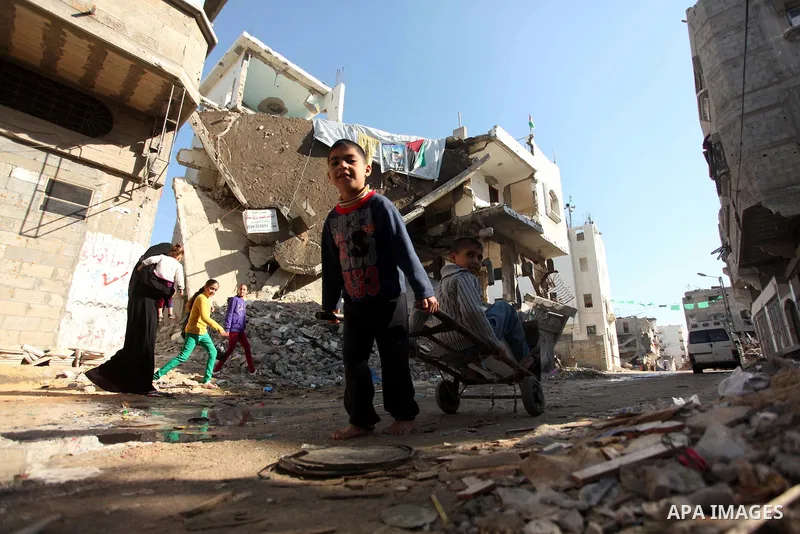 Palestinian children play between the rubble of houses which were destroyed during the recent Israeli offensive on Gaza Strip, in Shijaiyah neighborhood, east Gaza city December 25, 2014. Photo by Ashraf Amra