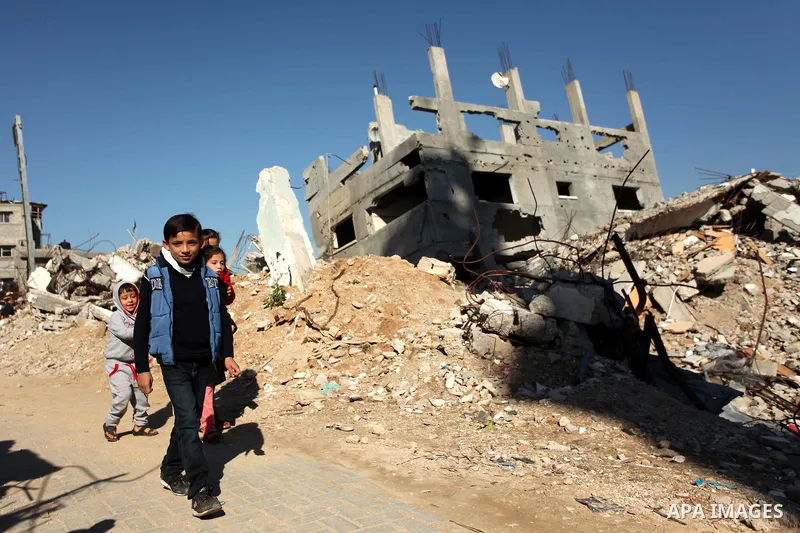 Palestinian children walk between the rubble of houses which were destroyed during the recent Israeli offensive on Gaza Strip, in Shijaiyah neighborhood, east Gaza city December 25, 2014. Photo by Ashraf Amra