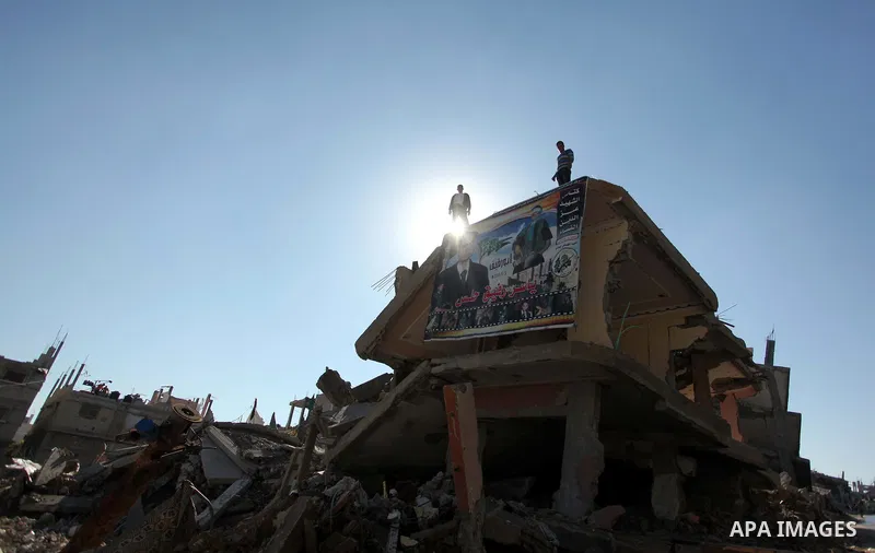 Palestinians hang a picture of their killed relative on the rubble of a house which was destroyed during the recent Israeli offensive on Gaza Strip, in Shijaiyah neighborhood, east Gaza city December 25, 2014. Photo by A...