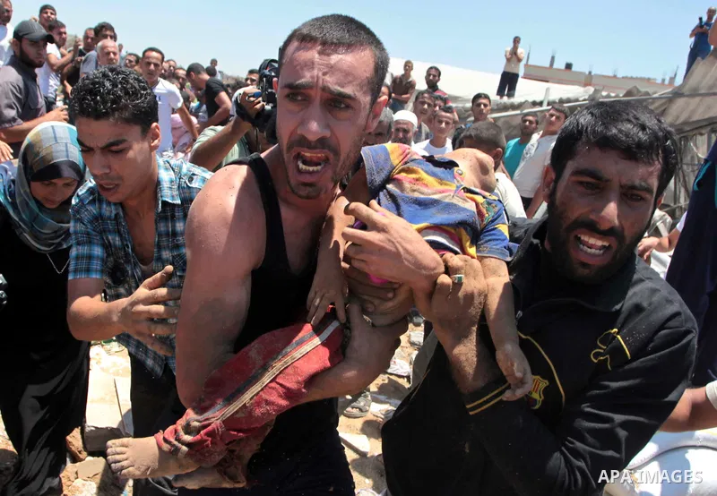 People carry the body of a Palestinian boy, whom hospital officials said was killed in an Israeli air strike on his family's house, in Gaza city July 9, 2014. Israeli air strikes shook Gaza every few minutes on Wednesday...