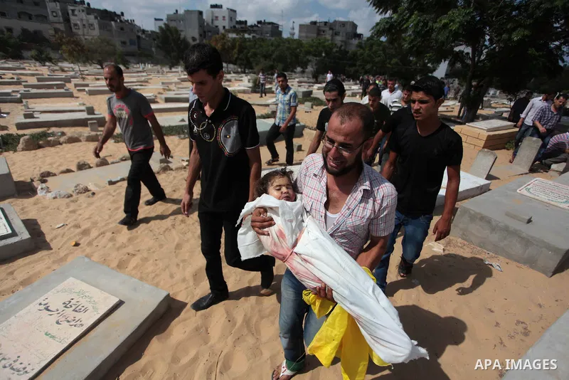 Palestinian relatives shout as they carry the bodies of kids during the funeral of eight members of Abu Jarad family who were killed overnight in an Israeli strike on July 19, 2014 in Beit Lahia, north of the Gaza strip....