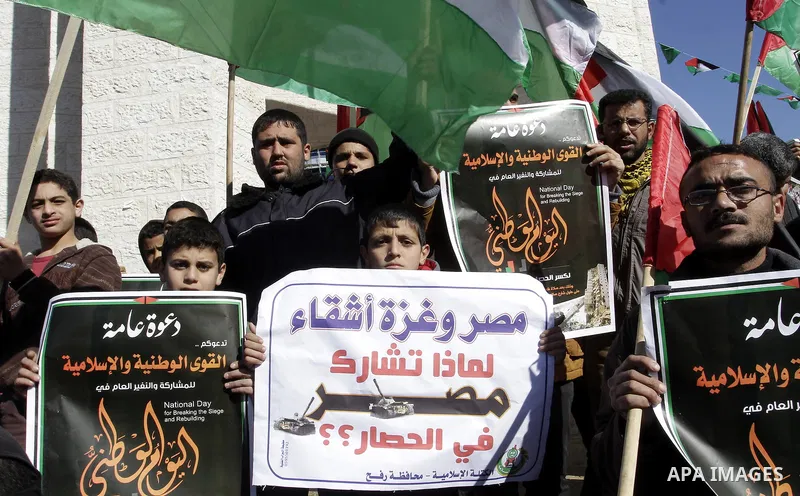 Palestinians take part in a protest calling for end the Israeli illegal blockade on Gaza Strip and against the slow rehabilitation of the strip after damage incurred during the recent Israeli offensive on Gaza Strip, in...