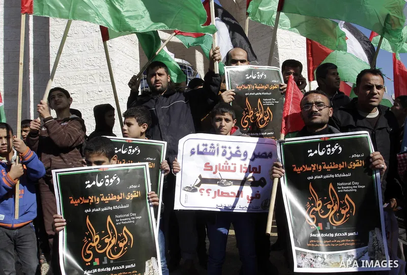 Palestinians take part in a protest calling for end the Israeli illegal blockade on Gaza Strip and against the slow rehabilitation of the strip after damage incurred during the recent Israeli offensive on Gaza Strip, in...