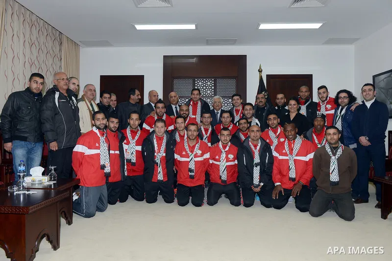 Palestinian President Mahmoud Abbas meets with members of national football team, at Abbas's headquarter, in the West Bank city of Ramallah, December 28, 2014. Photo by Thaer Ganaim