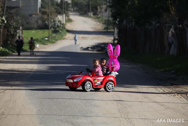Palestinian children ride a play car outside their house in the northern Gaza Strip town of Beit Lahia, in Gaza city December 29, 2014. Photo by Ashraf Amra