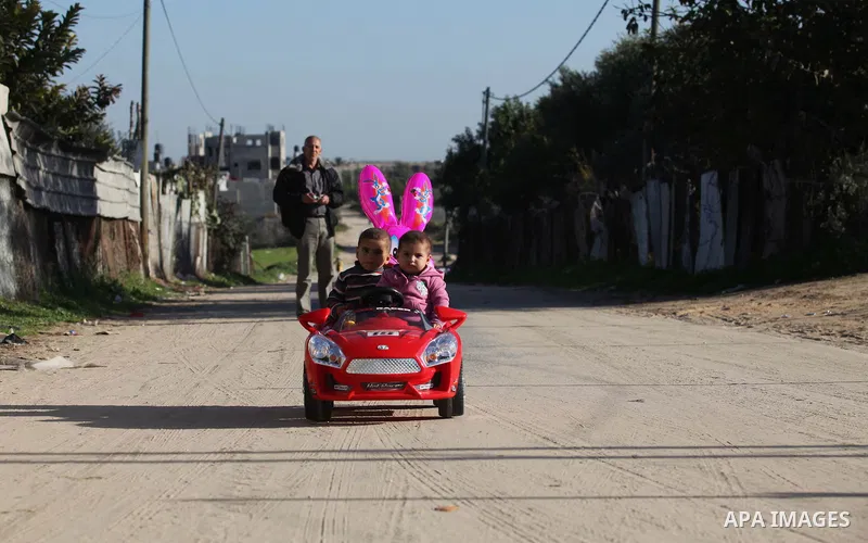 Palestinian children ride a play car outside their house in the northern Gaza Strip town of Beit Lahia, in Gaza city December 29, 2014. Photo by Ashraf Amra