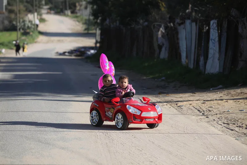 Palestinian children ride a play car outside their house in the northern Gaza Strip town of Beit Lahia, in Gaza city December 29, 2014. Photo by Ashraf Amra