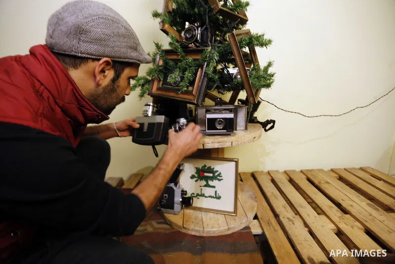 Palestinian Photographer, Elias Halabi, decorates a Christmas tree with cameras old at his house in the West Bank city of Bethlehem December 29, 2014. Photo by Muhesen Amren