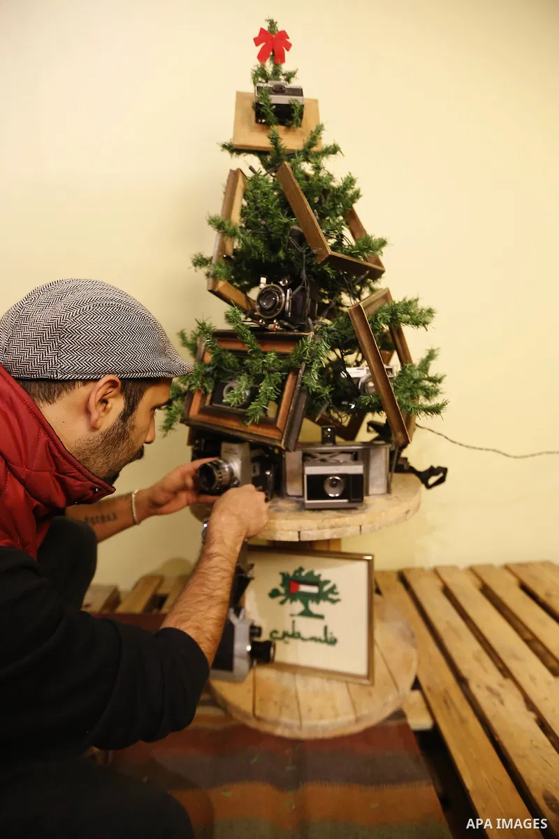 Palestinian Photographer, Elias Halabi, decorates a Christmas tree with cameras old at his house in the West Bank city of Bethlehem December 29, 2014. Photo by Muhesen Amren