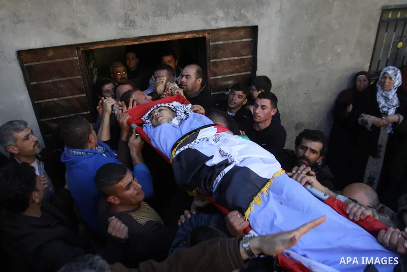 Mourners carry the body of 17-year-old Palestinian teenager Omam Dwekat, who was shot dead by Israeli troops the day before, during his funeral in the West Bank village of Baita, near of Nablus, on Dec. 30, 2014. Dwekat...