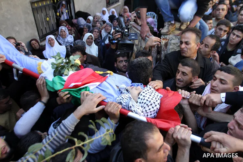 Mourners carry the body of 17-year-old Palestinian teenager Omam Dwekat, who was shot dead by Israeli troops the day before, during his funeral in the West Bank village of Baita, near of Nablus, on Dec. 30, 2014. Dwekat...