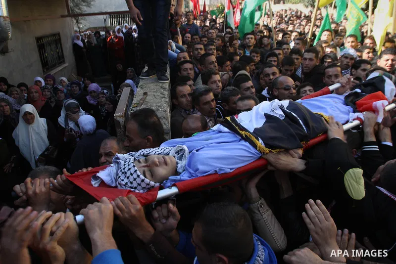 Mourners carry the body of 17-year-old Palestinian teenager Omam Dwekat, who was shot dead by Israeli troops the day before, during his funeral in the West Bank village of Baita, near of Nablus, on Dec. 30, 2014. Dwekat...