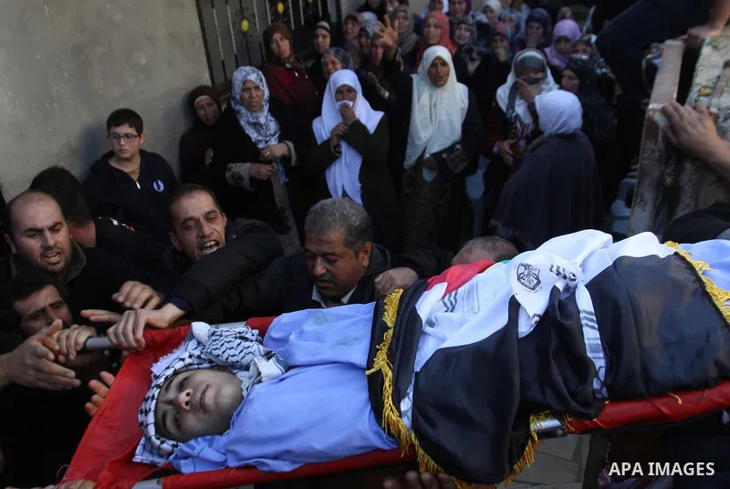 Mourners carry the body of 17-year-old Palestinian teenager Omam Dwekat, who was shot dead by Israeli troops the day before, during his funeral in the West Bank village of Baita, near of Nablus, on Dec. 30, 2014. Dwekat...