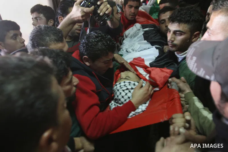 Mourners carry the body of 17-year-old Palestinian teenager Omam Dwekat, who was shot dead by Israeli troops the day before, during his funeral in the West Bank village of Baita, near of Nablus, on Dec. 30, 2014. Dwekat...