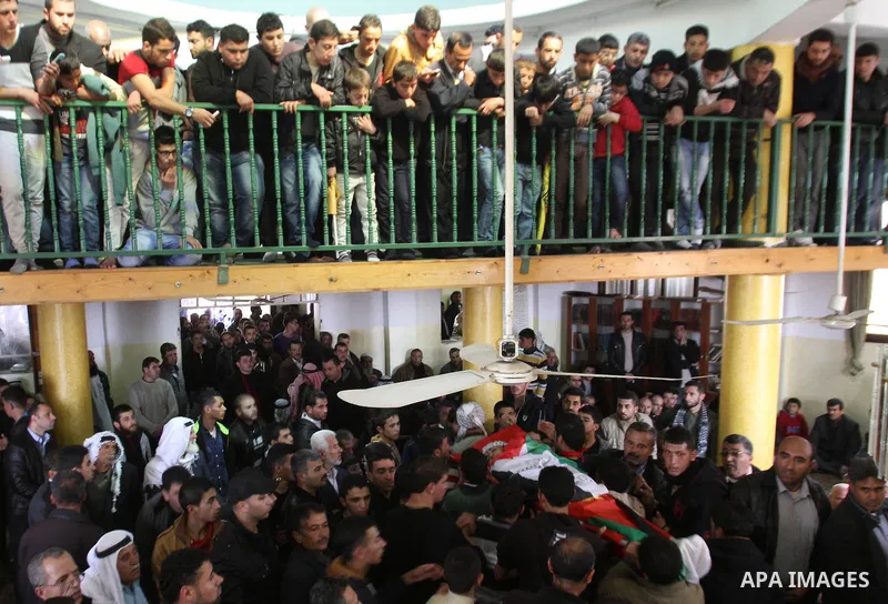 Mourners carry the body of 17-year-old Palestinian teenager Omam Dwekat, who was shot dead by Israeli troops the day before, during his funeral in the West Bank village of Baita, near of Nablus, on Dec. 30, 2014. Dwekat...
